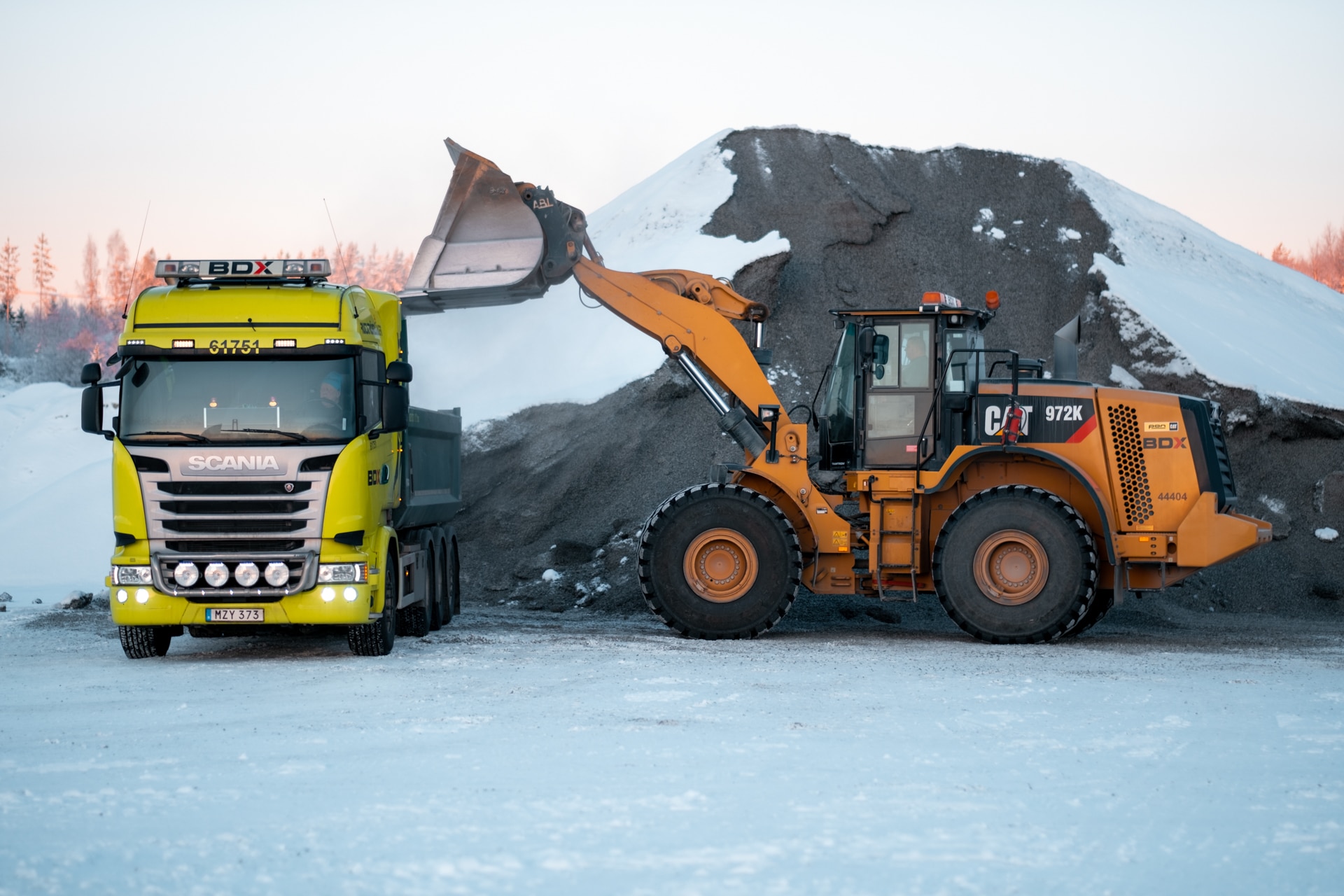 Grävmaskin i arbete i vinterlandskap